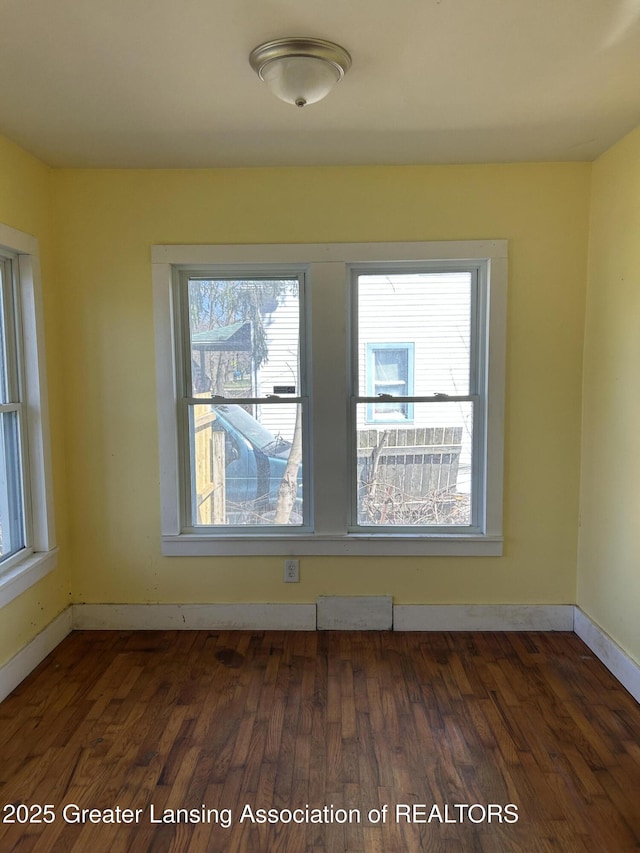 1909 W Holmes Rd, Lansing, MI 48910 - spare room featuring dark wood finished floors, baseboards, and visible vents