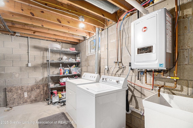 clothes washing area featuring a sink, washing machine and clothes dryer, tankless water heater, and laundry area