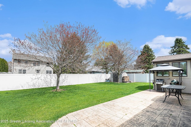 view of yard with a fenced backyard, a gazebo, an outbuilding, a patio area, and a shed