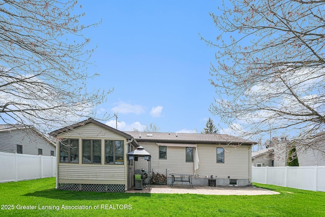 rear view of property with a sunroom, a patio, a lawn, and a fenced backyard