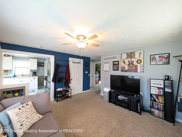 living area with a ceiling fan and light colored carpet
