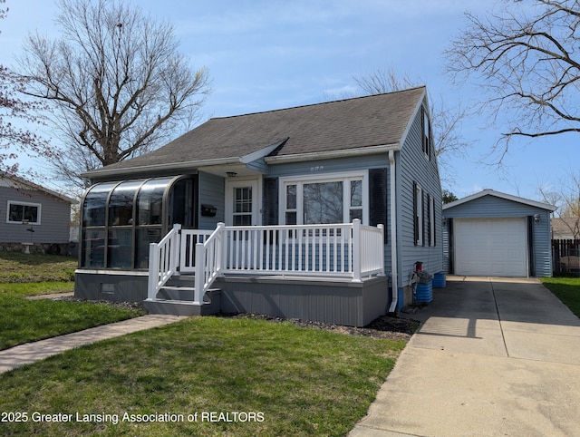 bungalow-style house with a shingled roof, a front lawn, driveway, an outdoor structure, and a sunroom