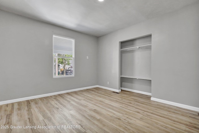 1435 New York Ave, Lansing, MI 48906 - unfurnished bedroom with baseboards, visible vents, wood finished floors, and a closet