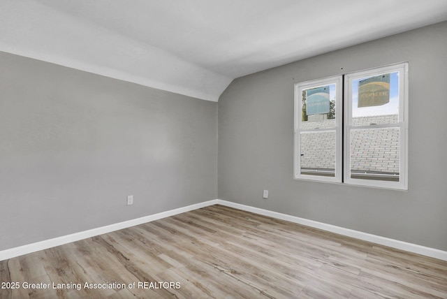 1435 New York Ave, Lansing, MI 48906 - bonus room featuring baseboards, vaulted ceiling, and light wood finished floors