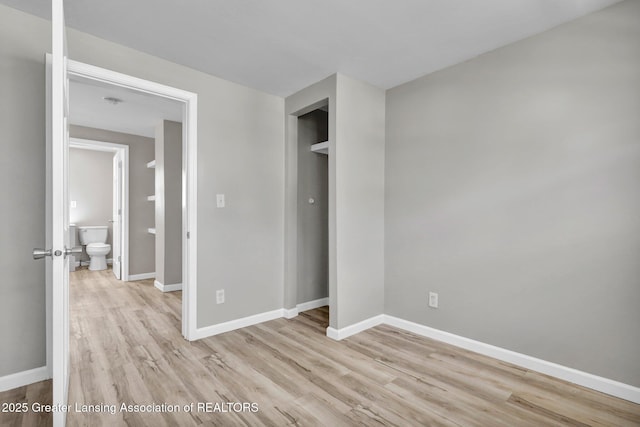 1435 New York Ave, Lansing, MI 48906 - unfurnished bedroom with a closet, baseboards, and light wood-style floors