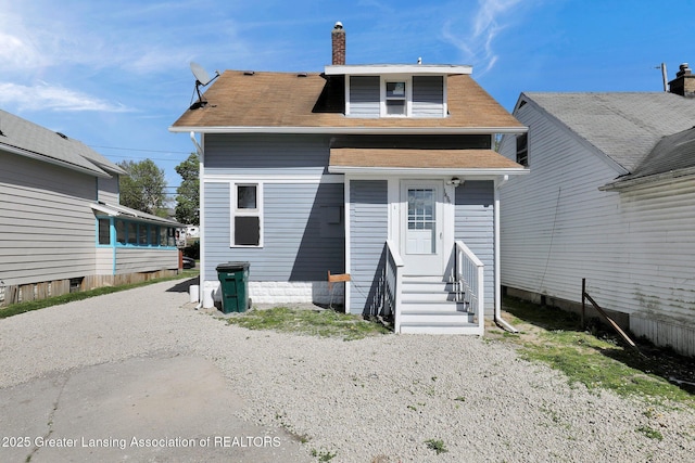1435 New York Ave, Lansing, MI 48906 - back of property with a chimney, a shingled roof, and entry steps