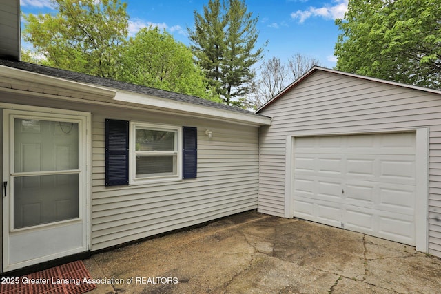 218 W Thomas St, Lansing, MI 48906 - view of property exterior with a garage, a shingled roof, and driveway