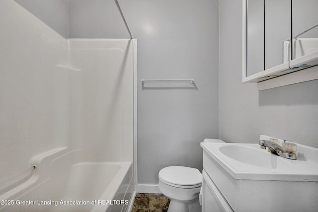 218 W Thomas St, Lansing, MI 48906 - bathroom featuring vanity, toilet, washtub / shower combination, and baseboards