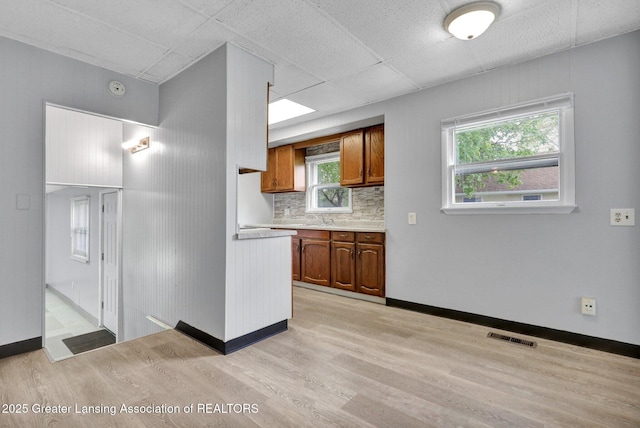218 W Thomas St, Lansing, MI 48906 - kitchen featuring brown cabinets, light countertops, light wood-type flooring, and visible vents