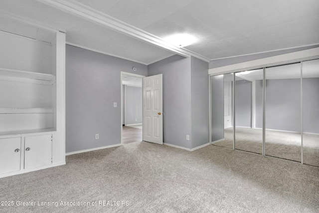 218 W Thomas St, Lansing, MI 48906 - unfurnished bedroom with baseboards, carpet flooring, a closet, and crown molding