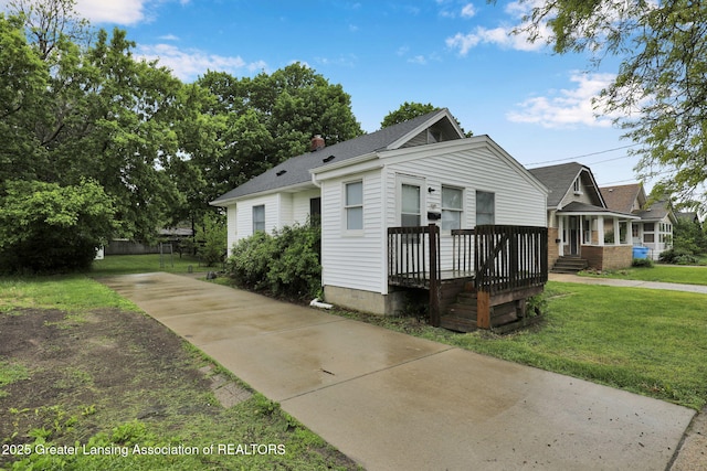 425 Filley St, Lansing, MI 48906 - bungalow with a front lawn, driveway, a chimney, and a shingled roof