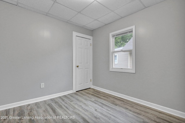 425 Filley St, Lansing, MI 48906 - unfurnished room featuring a drop ceiling, wood finished floors, and baseboards