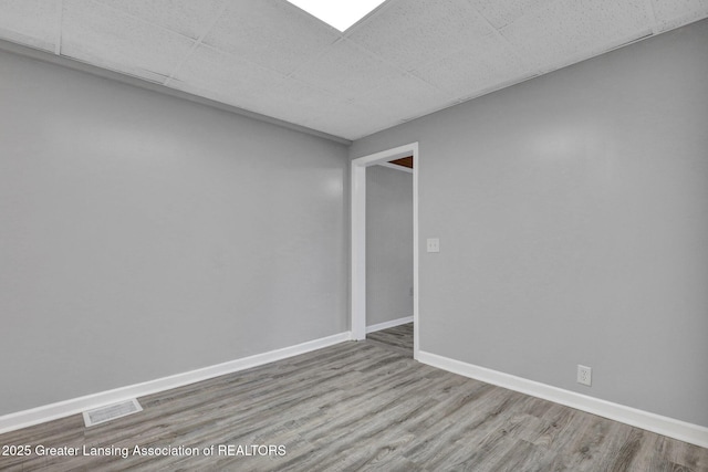 425 Filley St, Lansing, MI 48906 - empty room with wood finished floors, baseboards, and a paneled ceiling