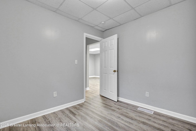 425 Filley St, Lansing, MI 48906 - empty room with a paneled ceiling, wood finished floors, and baseboards