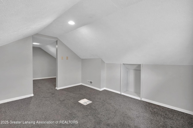 425 Filley St, Lansing, MI 48906 - bonus room with dark carpet, a textured ceiling, vaulted ceiling, baseboards, and recessed lighting