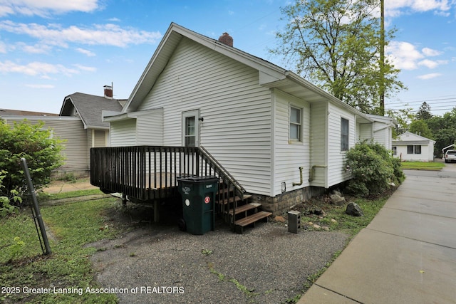 425 Filley St, Lansing, MI 48906 - view of side of home featuring a chimney and a deck