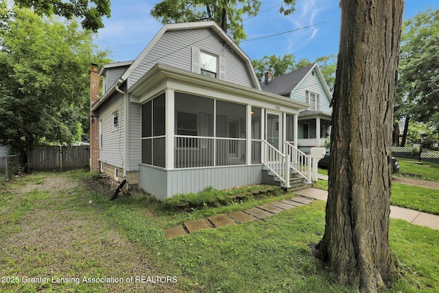 908 Larned St, Lansing, MI 48912 - dutch colonial featuring a sunroom, a chimney, and a gambrel roof