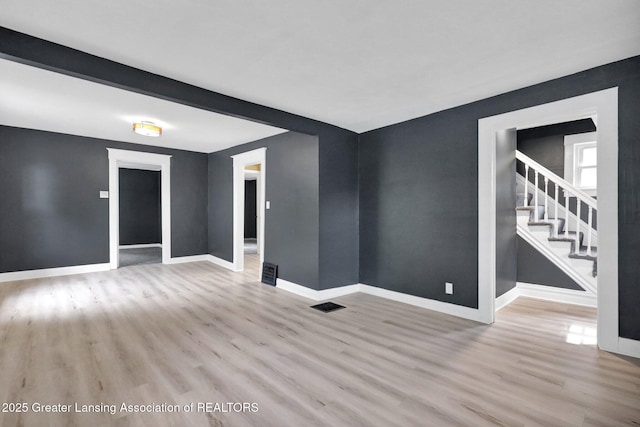 908 Larned St, Lansing, MI 48912 - spare room with wood finished floors, baseboards, and stairway
