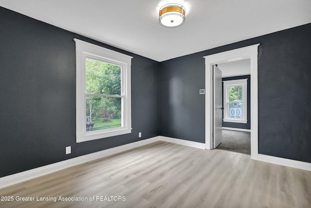 908 Larned St, Lansing, MI 48912 - unfurnished room with wood finished floors, healthy amount of natural light, and baseboards