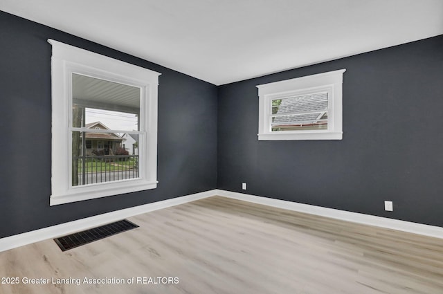 908 Larned St, Lansing, MI 48912 - unfurnished room with wood finished floors, plenty of natural light, and baseboards