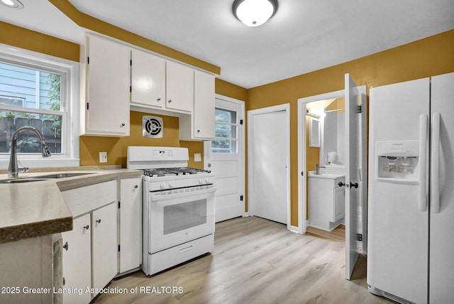908 Larned St, Lansing, MI 48912 - kitchen with white appliances, a sink, white cabinets, and light wood finished floors