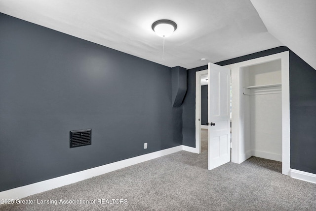 908 Larned St, Lansing, MI 48912 - unfurnished bedroom featuring carpet floors, a closet, baseboards, and lofted ceiling