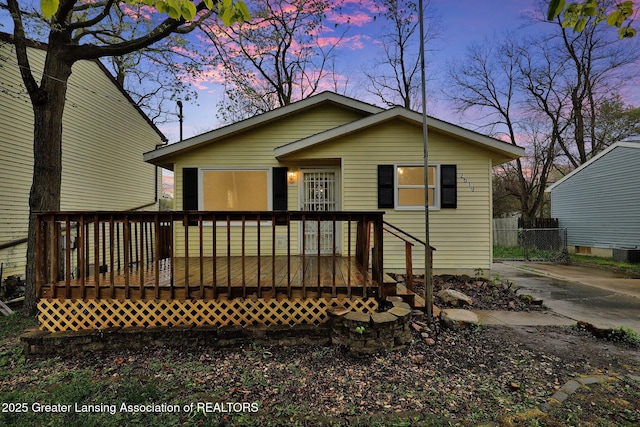 2619 Schippell St, Holt, MI 48842 - back of property at dusk featuring fence and a wooden deck