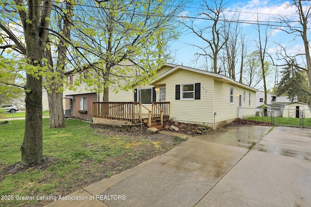2619 Schippell St, Holt, MI 48842 - single story home with fence, a wooden deck, and a front yard