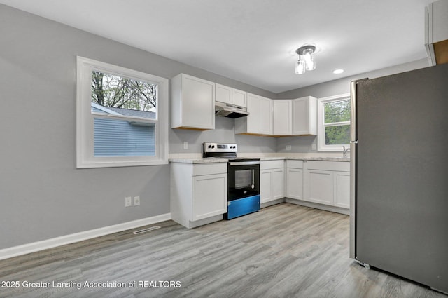 2619 Schippell St, Holt, MI 48842 - kitchen with range with electric cooktop, freestanding refrigerator, white cabinetry, under cabinet range hood, and visible vents