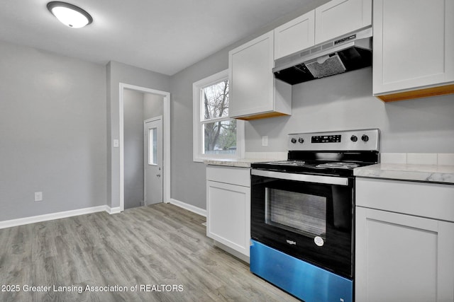 2619 Schippell St, Holt, MI 48842 - kitchen with light countertops, electric range oven, under cabinet range hood, and white cabinets