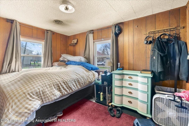 carpeted bedroom with wood walls