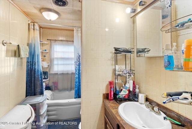 full bath with crown molding, vanity, shower / tub combo with curtain, tile walls, and toilet
