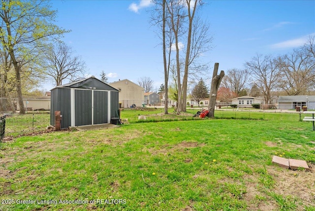 view of yard with fence, an outbuilding, and a shed