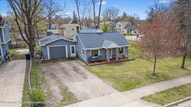 view of front of home featuring a residential view, roof with shingles, driveway, covered porch, and a front yard