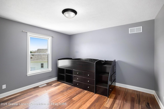 12714 Ospreys Way, Dewitt, MI 48820 - bedroom with baseboards, visible vents, and wood finished floors