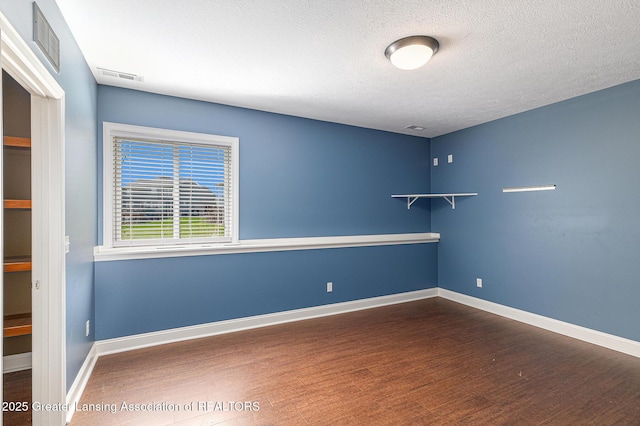 12714 Ospreys Way, Dewitt, MI 48820 - spare room with wood finished floors, visible vents, baseboards, and a textured ceiling