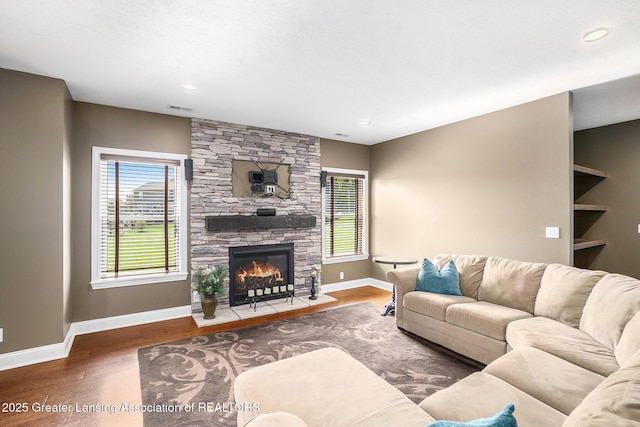 12714 Ospreys Way, Dewitt, MI 48820 - living area featuring a fireplace, wood finished floors, visible vents, and baseboards