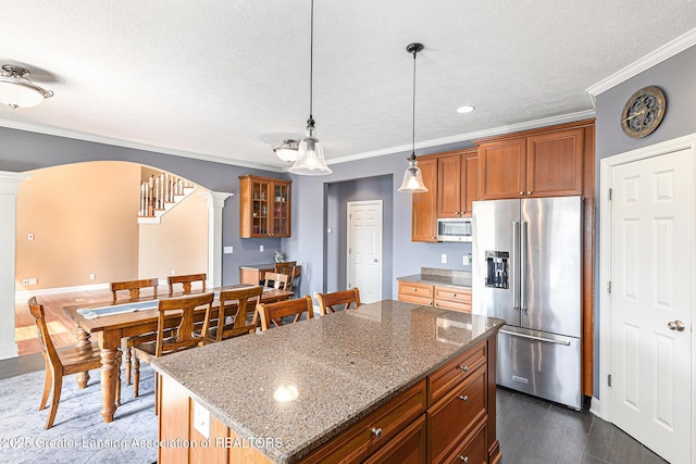 12714 Ospreys Way, Dewitt, MI 48820 - kitchen featuring arched walkways, decorative columns, stainless steel appliances, ornamental molding, and a textured ceiling
