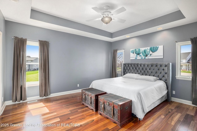 12714 Ospreys Way, Dewitt, MI 48820 - bedroom with a raised ceiling, ceiling fan, visible vents, baseboards, and wood finished floors