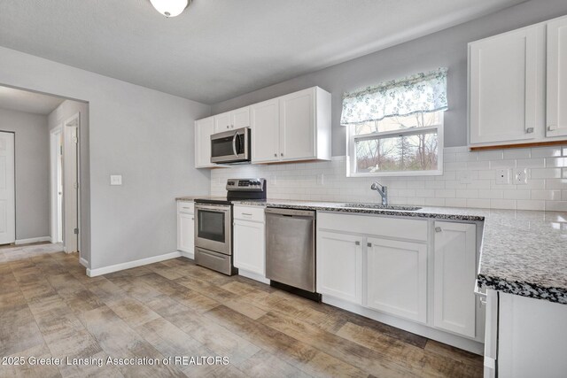 12001 Bryde Dr, Rives Junction, MI 49277 - kitchen featuring a sink, white cabinetry, and stainless steel appliances