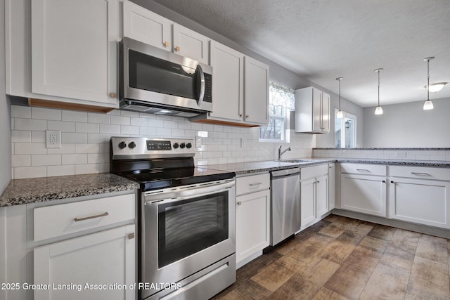 12001 Bryde Dr, Rives Junction, MI 49277 - kitchen featuring a sink, white cabinets, stainless steel appliances, and dark wood finished floors