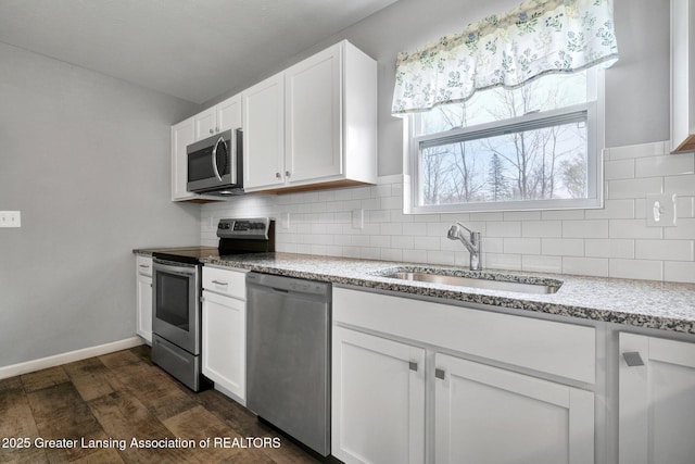 12001 Bryde Dr, Rives Junction, MI 49277 - kitchen featuring dark wood-style floors, appliances with stainless steel finishes, decorative backsplash, and a sink