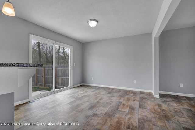 12001 Bryde Dr, Rives Junction, MI 49277 - unfurnished room featuring visible vents, baseboards, and wood finished floors
