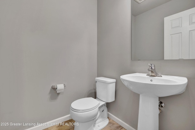 12001 Bryde Dr, Rives Junction, MI 49277 - half bath with baseboards, wood finished floors, and toilet