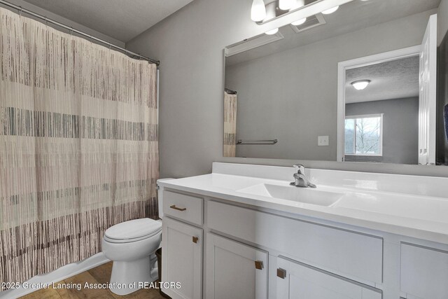 12001 Bryde Dr, Rives Junction, MI 49277 - full bath featuring wood finished floors, toilet, curtained shower, and vanity