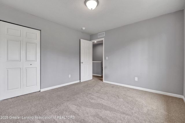 12001 Bryde Dr, Rives Junction, MI 49277 - unfurnished bedroom featuring baseboards, carpet, a closet, and visible vents