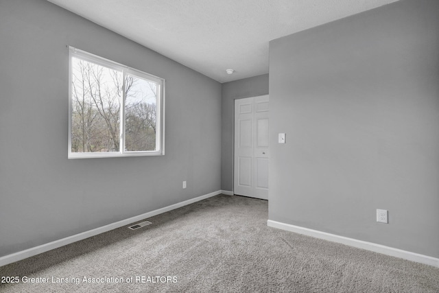 12001 Bryde Dr, Rives Junction, MI 49277 - empty room featuring carpet floors, baseboards, and visible vents