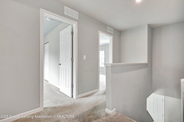 12001 Bryde Dr, Rives Junction, MI 49277 - corridor with carpet floors, baseboards, an upstairs landing, and visible vents