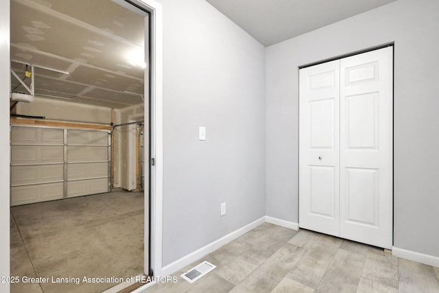 12001 Bryde Dr, Rives Junction, MI 49277 - garage with baseboards, visible vents, and a garage door opener