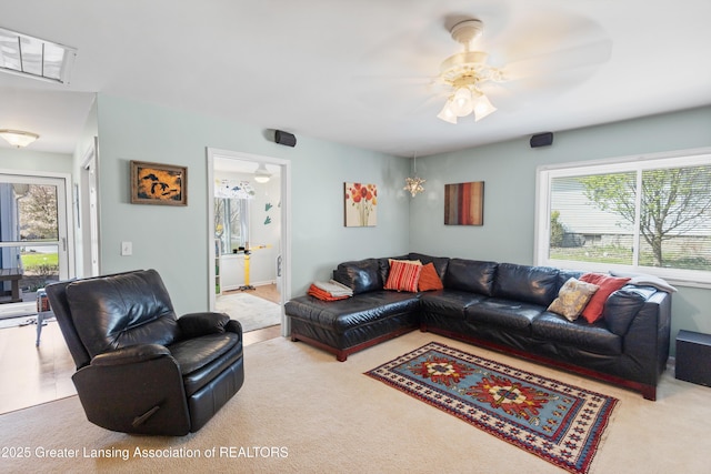 living area with plenty of natural light, carpet flooring, and a ceiling fan